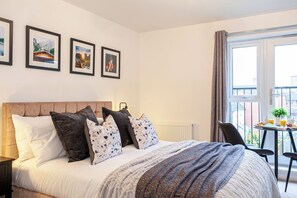 Ein Hotelzimmer mit Bett, einem kleinen Tisch mit Frühstück und einem Balkon mit Blick.