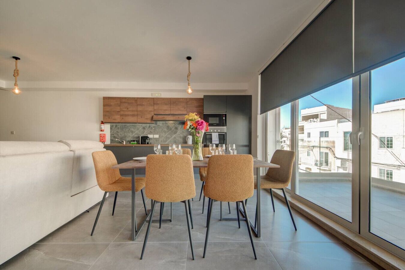 Un salon moderne avec un coin repas, de grandes fenêtres et une vue sur la ville.