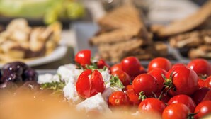 Variedad de alimentos como tomates, aceitunas y queso sobre una mesa.