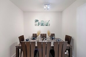 Ein Essbereich mit einem rechteckigen Tisch, gedeckt für sechs Personen, umgeben von sechs Stühlen.