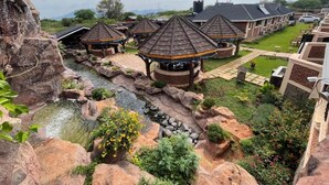 Ein Resort mit mehreren Pavillons, einem zentralen Wasserelement und einem gepflegten Garten.