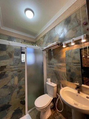 Deluxe tweepersoonskamer | Badkamer | Een douche, pantoffels, handdoeken, zeep