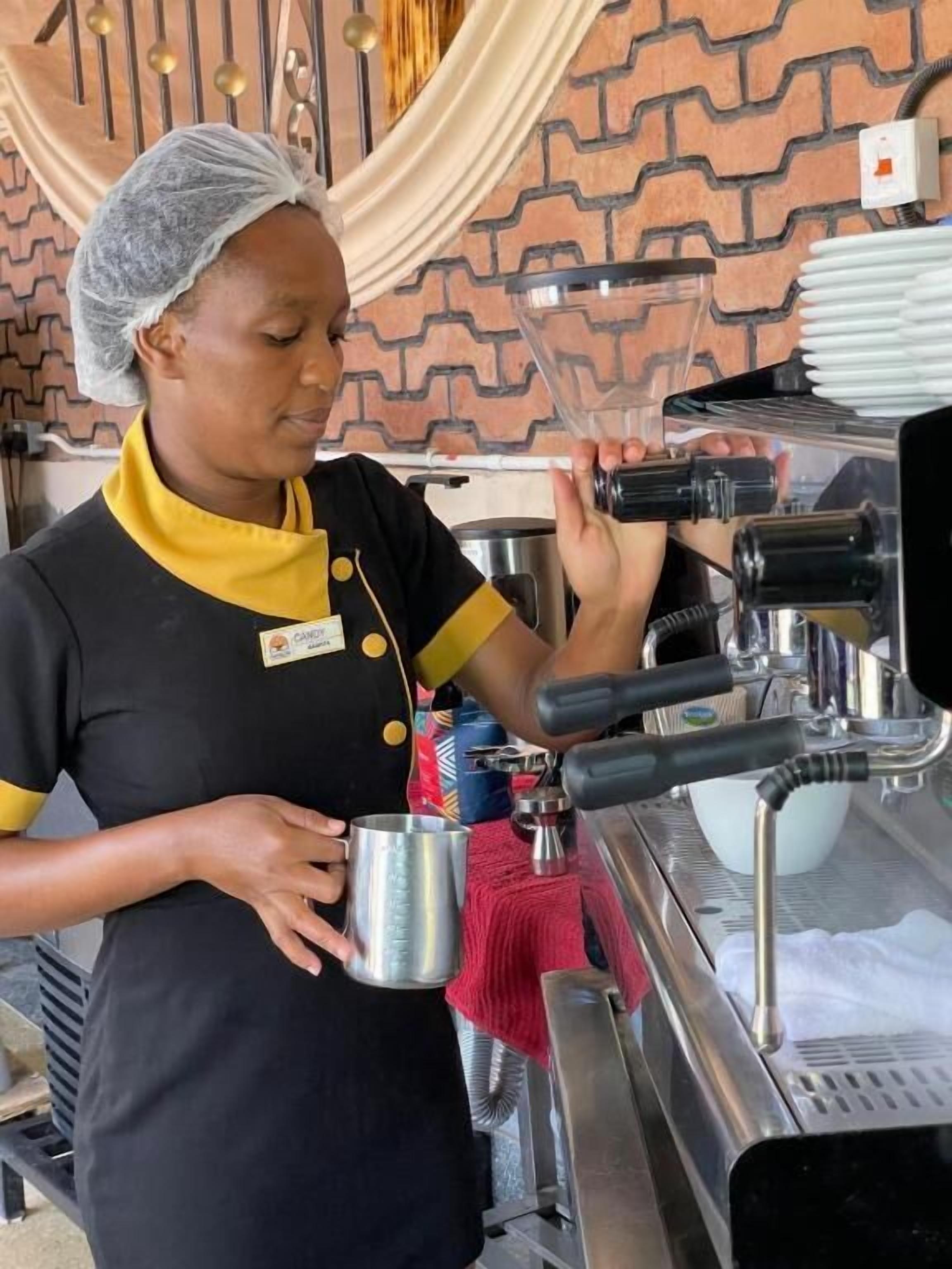 A person preparing a beverage at a coffee machine.