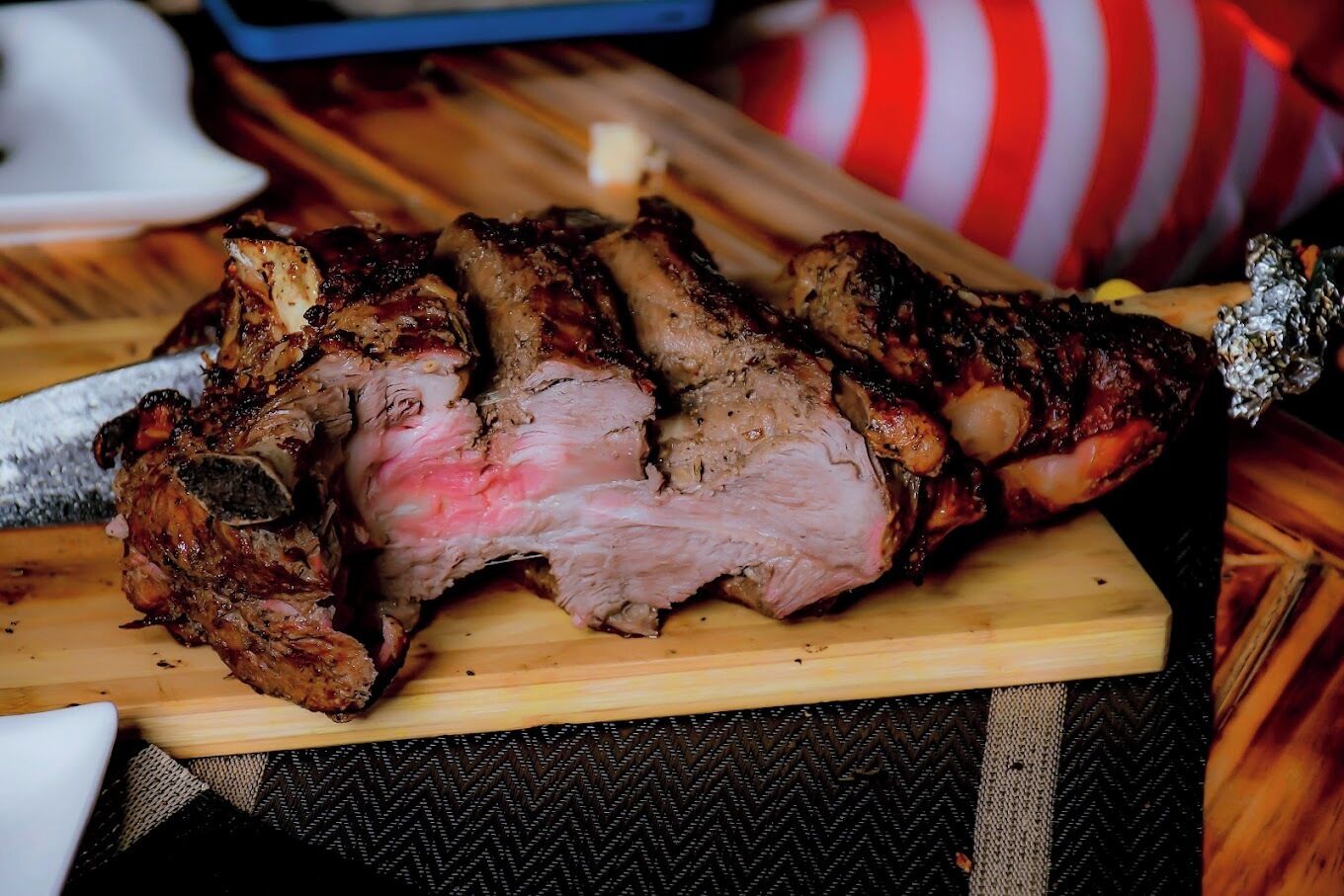 Un grand plat de viande rôtie, présenté sur une planche à découper en bois.