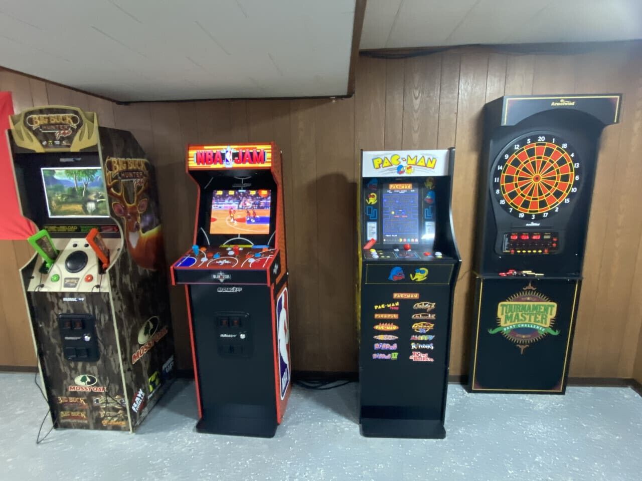 Four arcade machines: Big Buck Hunter, WBA JAM, Pac-Man, and Tournament Master.
