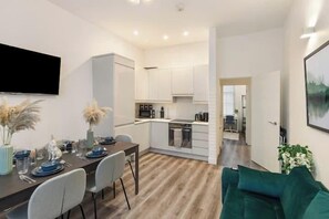 A modern apartment with a dining area, kitchen, and living room. - Apartment - Sleeps 7 - Paddington Station 5 mins (London)