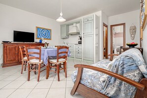 Een eetgedeelte met een tafel, stoelen en een televisie.