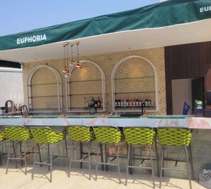 A bar area with a green awning labeled 'EUPHORIA,' bar stools, and a patterned wall. - Opulent Designer Living Space with Premium Comfort & Style 3-bedroom Ikoyi Lagos (Lagos)