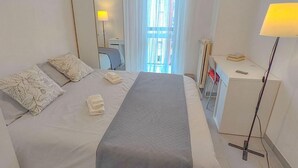 A hotel room with a bed, a desk, a chair, a lamp, and a window with curtains. - Private room quiet North Park Bresso Milan (Bresso)