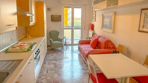 A compact living space with a kitchenette, a sofa, a dining table, and a small chair. - Private room quiet North Park Bresso Milan (Bresso)