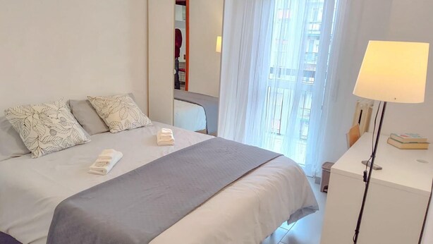 A hotel room with a bed, a bedside table with a lamp, and a window with sheer curtains. - Private room quiet North Park Bresso Milan (Bresso)