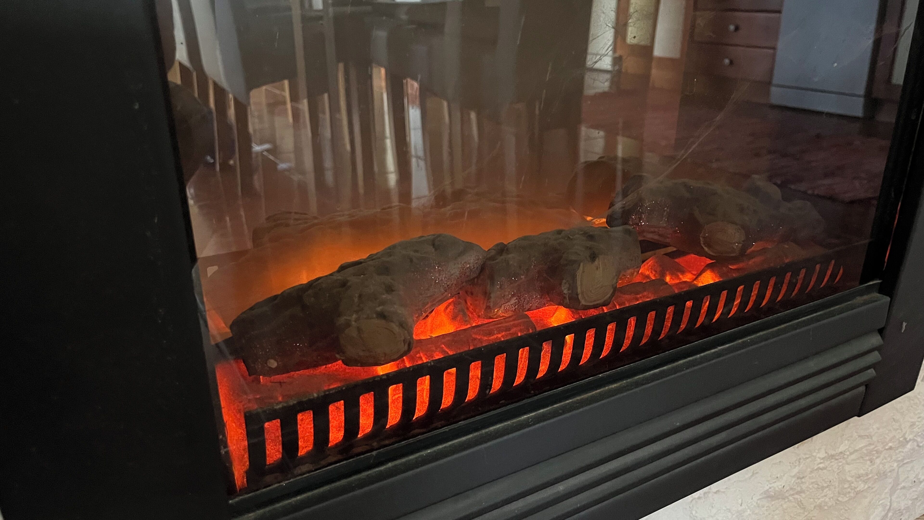 A fireplace with logs burning inside.