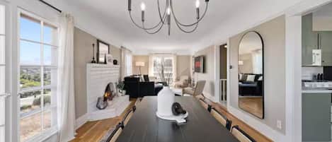 Un salón espacioso con una gran mesa de comedor, chimenea y vistas al exterior.