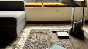 A cozy living room with a sofa, a coffee table, and a bookshelf.