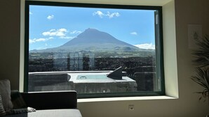 A room with a large window offering a view of a mountain.
