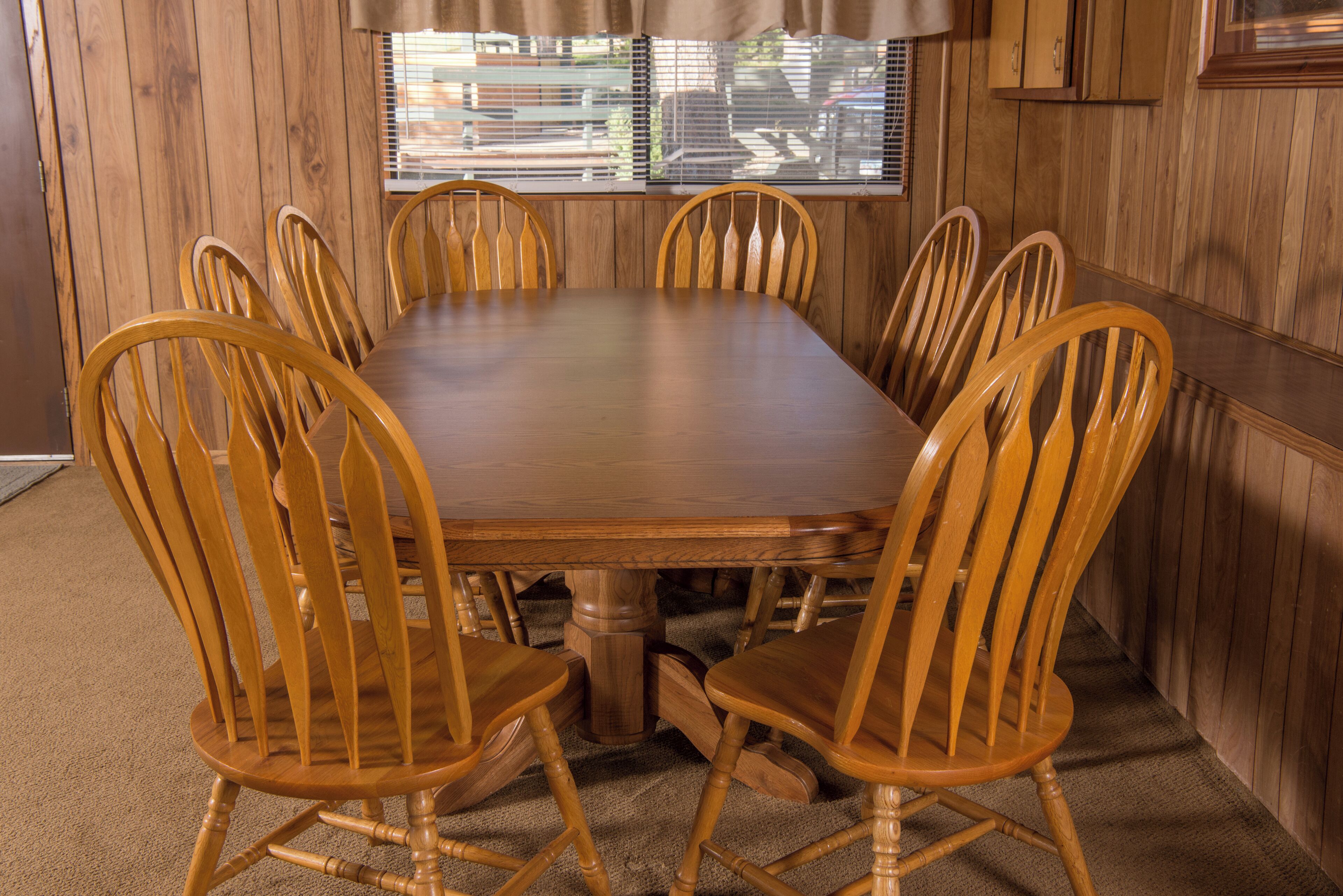 A rectangular wooden table surrounded by six wooden chairs with curved backs.