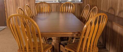 A rectangular wooden table surrounded by six wooden chairs with curved backs.