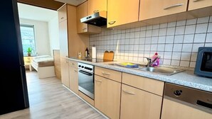 Eine moderne Küche mit Holzausstattung, einer Edelstahlspüle und einem eingebauten Backofen.