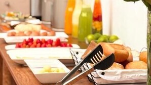 A buffet table with various food items and a coffee machine in the background. - Horizonte Hotels (Cusco)