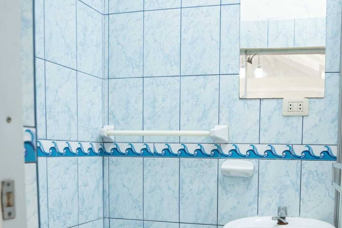 A bathroom with a toilet, a sink, and a mirror.
