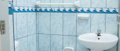 A bathroom with a toilet, a sink, and a mirror.