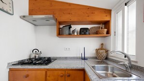A kitchen with granite countertops, wooden cabinets, a built-in stove, a sink, and a window.