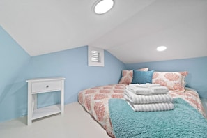 Un dormitorio con cama, mesita de noche y ventana con persianas.