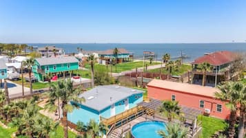 Zona residencial con una amplia piscina, varias casas y vistas al océano.