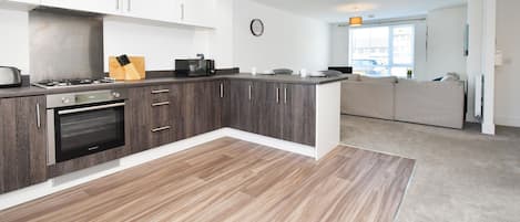 Eine moderne Küche mit Backofen, Kaffeemaschine und einem Messerblock.