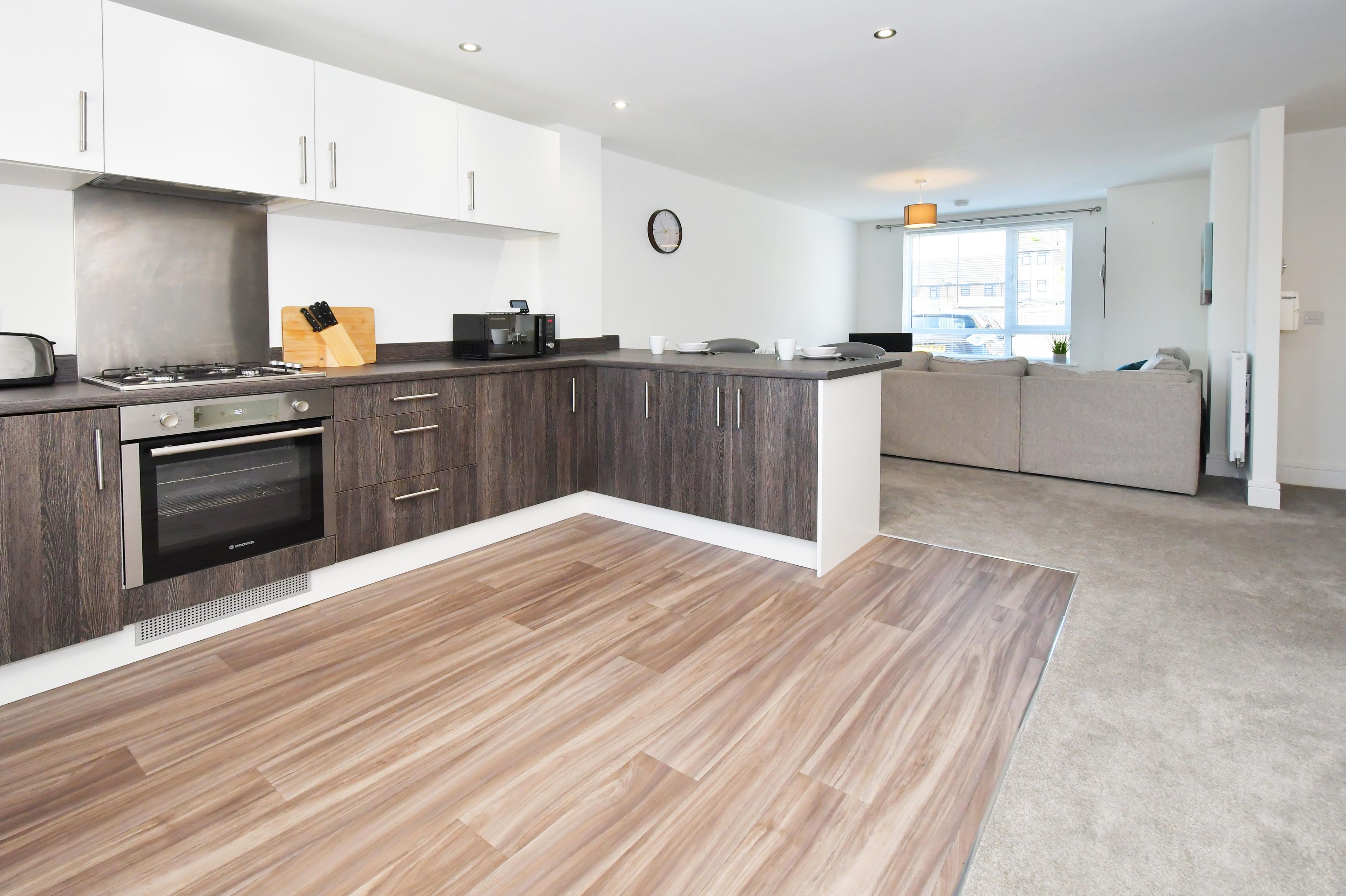 A modern kitchen with a built-in oven, a coffee machine, and a knife block.
