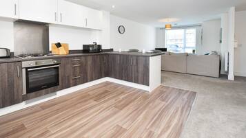A modern kitchen with a built-in oven, a coffee machine, and a knife block.