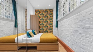 A modern bedroom with a wooden bed, white walls, and a floral wallpaper. - Royal College St NW1 🚇 Camden Town 🚇 Camden Rd (London)