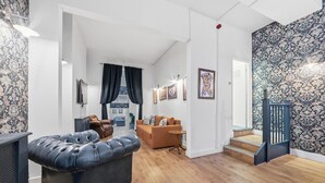A modern living room with a leather sofa, a brown leather chair, and a wooden coffee table. - Royal College St NW1 🚇 Camden Town 🚇 Camden Rd (London)