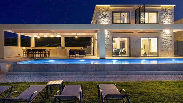 A modern house with a swimming pool, outdoor seating, and a stone facade. - Luxurious Villa Rocca Blanco 2 (Chania)