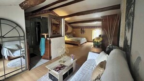 Acogedor dormitorio en ático con cama, sofá y mesa de comedor.