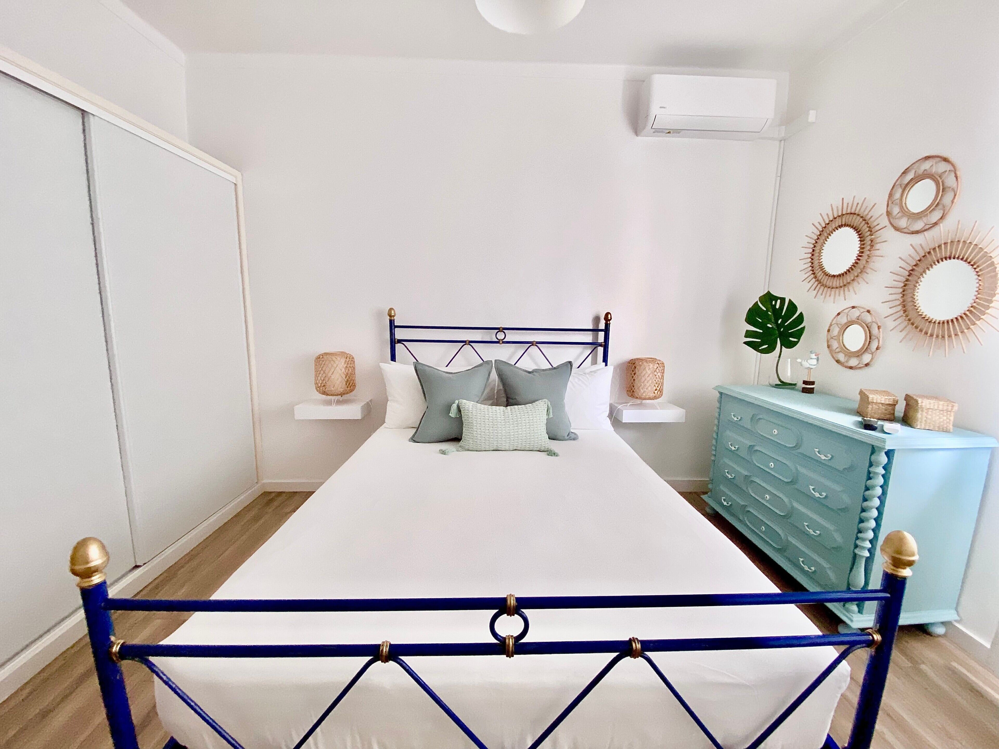 Une chambre à coucher comprenant un lit, des tables de chevet, une commode et des éléments de décoration murale.