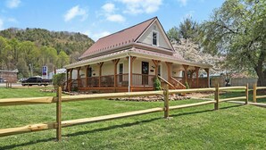 A historic building with a porch, wooden fence, and a grassy area. - Delightful Appalachian Trail 2-bedroom lodge with AC in Central Damascus (Damascus)