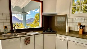 Eine Küche mit einem großen Fenster, einem Geschirrspüler und einer Arbeitsfläche mit verschiedenen Gegenständen.
