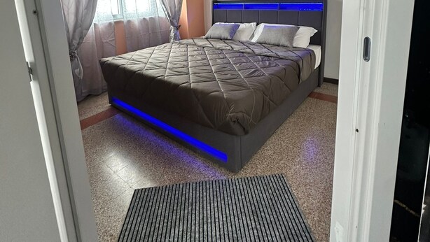 Un dormitorio con cama, cortinas, una obra de arte en la pared y un diseño en el techo.