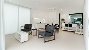 A modern, open-plan living space with a kitchen, dining area, and seating area. - Very beautiful villa a few steps from the beach (Marina di Ragusa)