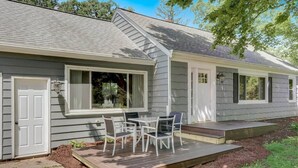 Une maison à deux étages avec une terrasse couverte et une plateforme.