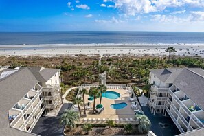 A resort with a pool area, beach view, and multiple buildings.