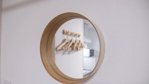 A round mirror with a wooden frame on a white wall. - Triphome Shinokubo WUJI New Open (Shinjuku City)