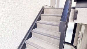 Eine Treppe mit strukturierter Wand und Metallgeländer.