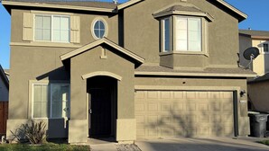 A two-story house with a garage, a front entrance, and a satellite dish. - Spacious 5 bedroom House-Perfect for Families & Groups (Turlock)