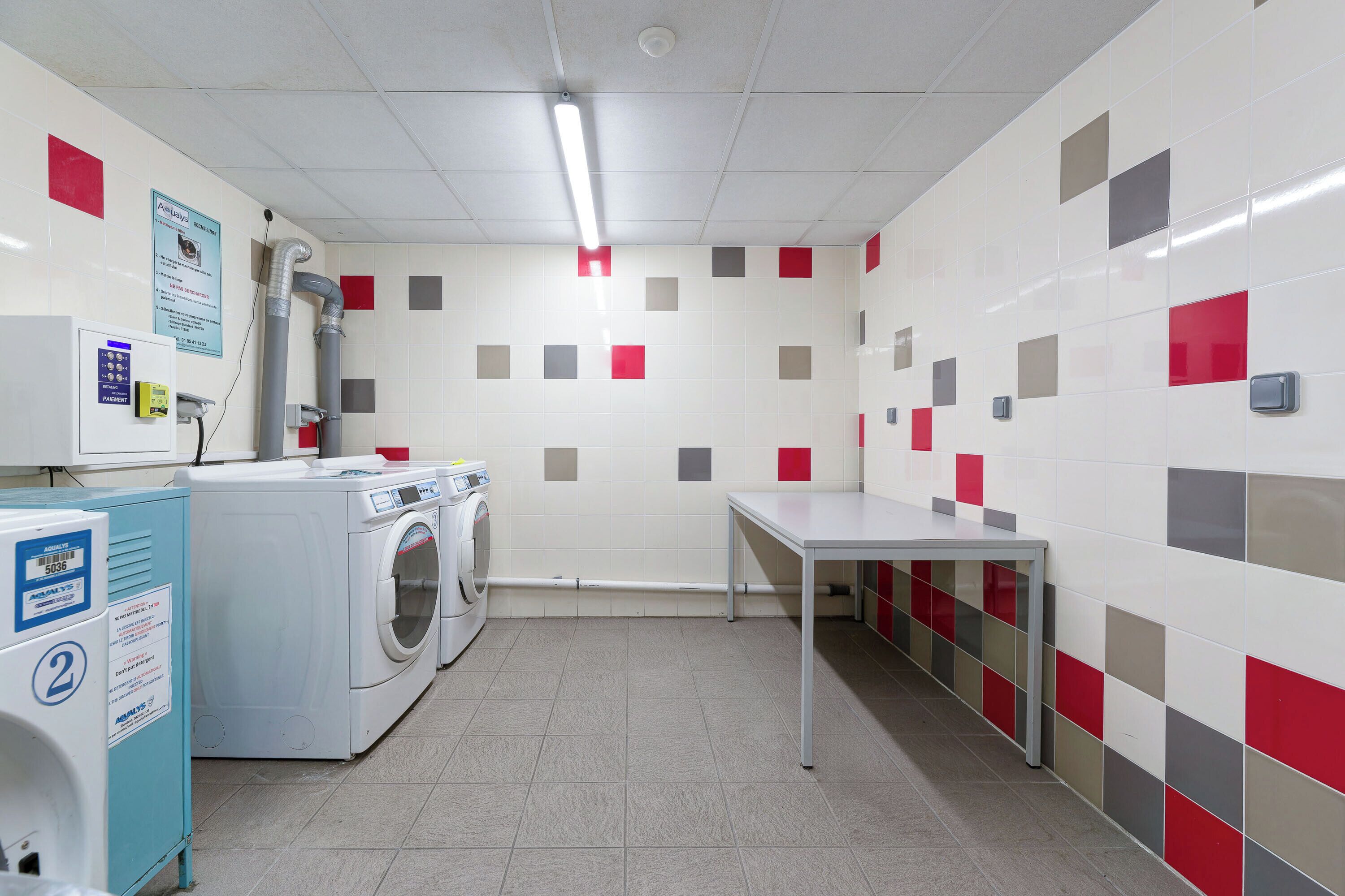 A laundry room with a washing machine, dryer, and a table.