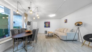 Una sala de estar moderna con comedor, un sofá y una lámpara de pie.
