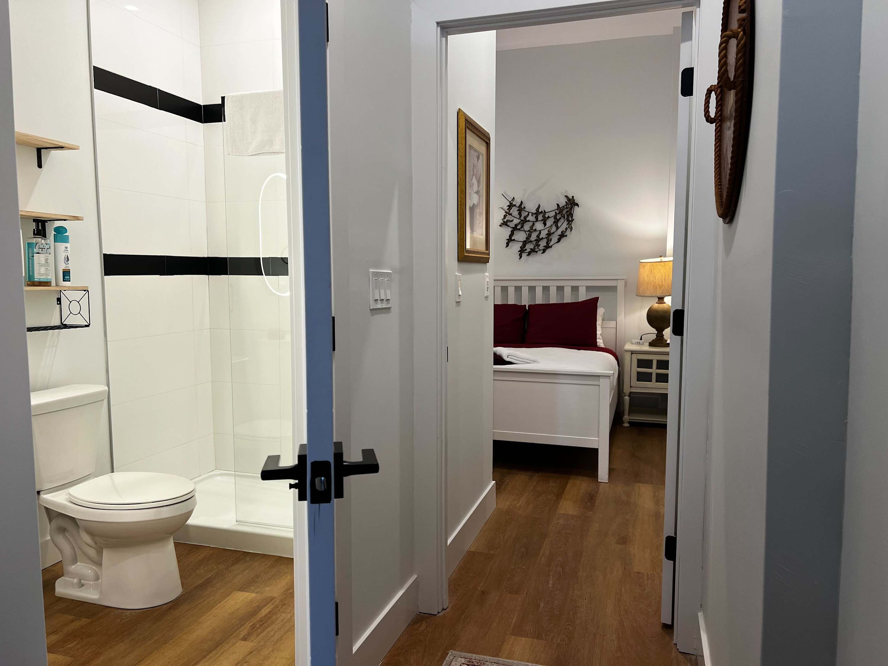 Une salle de bain équipée de toilettes, d’une douche et d’une petite étagère où sont rangés les articles de toilette.