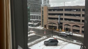 Overzicht van een meerlaags parkeergarage met een 'Metro Park' bord, een 'PLE' gebouw en een stopbord.