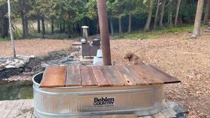 Un entorno rústico al aire libre con un contenedor metálico que muestra la inscripción "Behlen Country Farm & Ranch Equipment" como elemento principal.